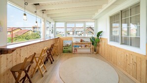 Ein gemütliches Zimmer mit Holzwänden, großen Fenstern und Blick auf die Nachbarschaft.