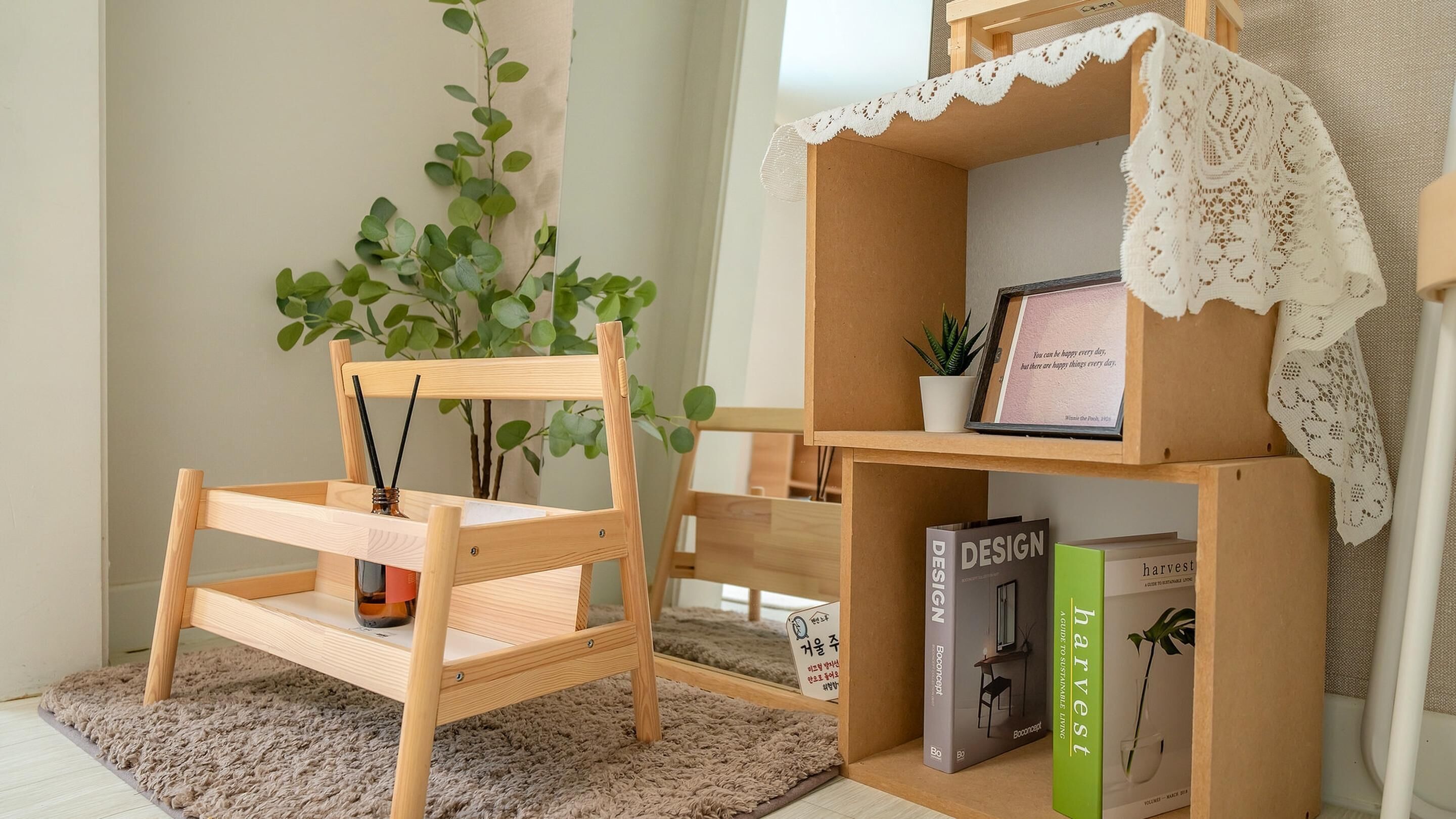 Una habitación acogedora con una silla de madera, un pequeño estante de libros y una planta en maceta.