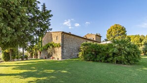 A stone building with a well-maintained lawn and trees. - Casale Al Sole Tra Le Vecchie Vigne, Radda in Chianti (Radda in Chianti)