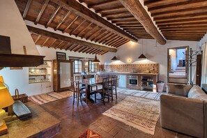 A spacious living area with a wooden ceiling, a dining table, and a sofa.