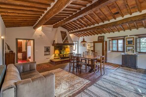 A spacious living area with a wooden ceiling, a dining table, and a sofa.