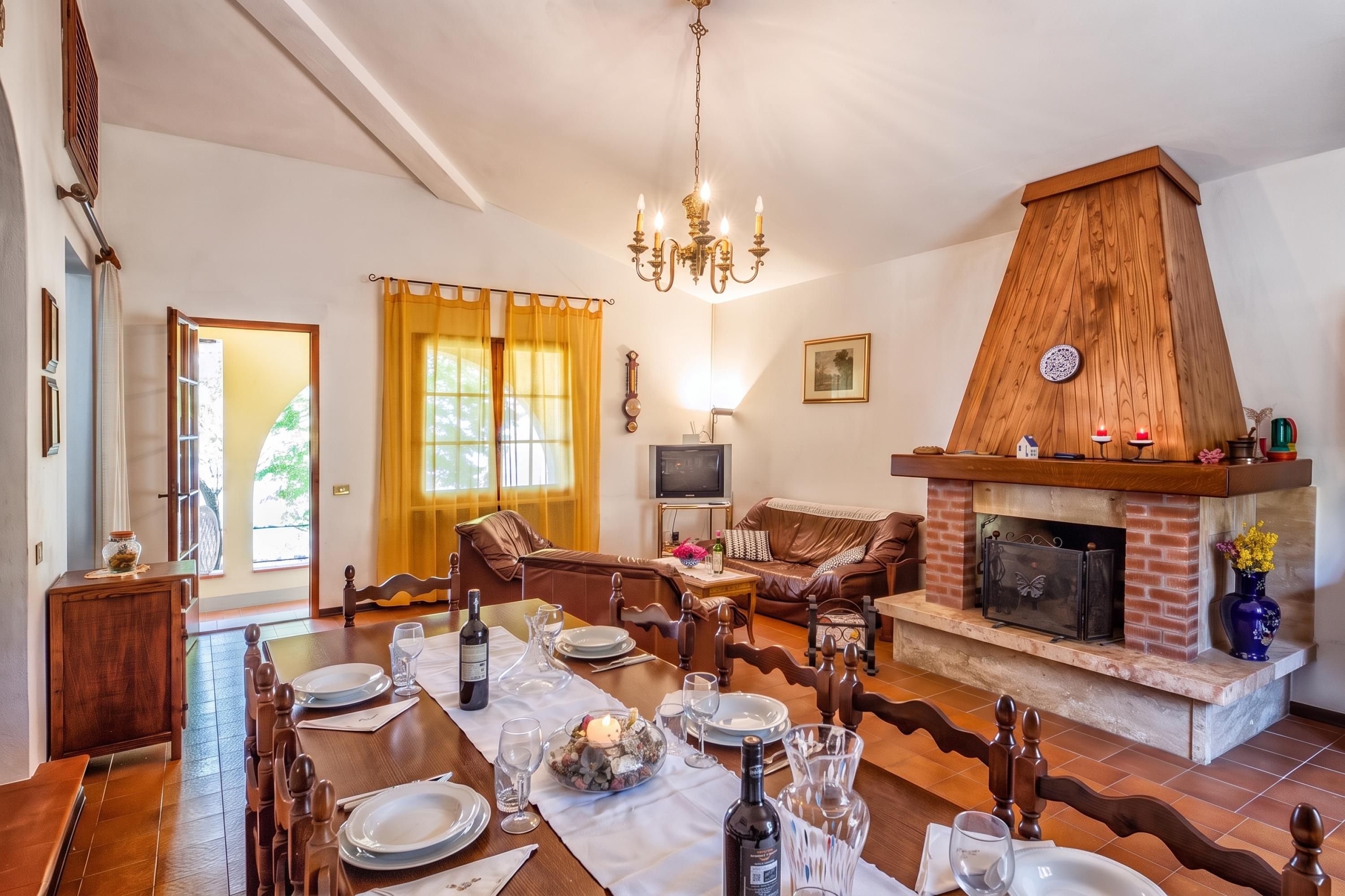 A dining area with a fireplace, wooden furniture, and a television.