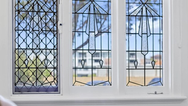 Una habitación con cama, una ventana con vidrieras y vistas al exterior.