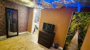 A bedroom with a bed, dresser, and a wall mural of a forest path. - This special place is close to everything, making it easy to plan your visit.  (Smyrna)