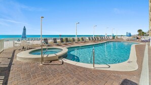 A swimming pool with a view of the ocean, lounge chairs, and umbrellas. - Seychelles 2103 (Panama City Beach)