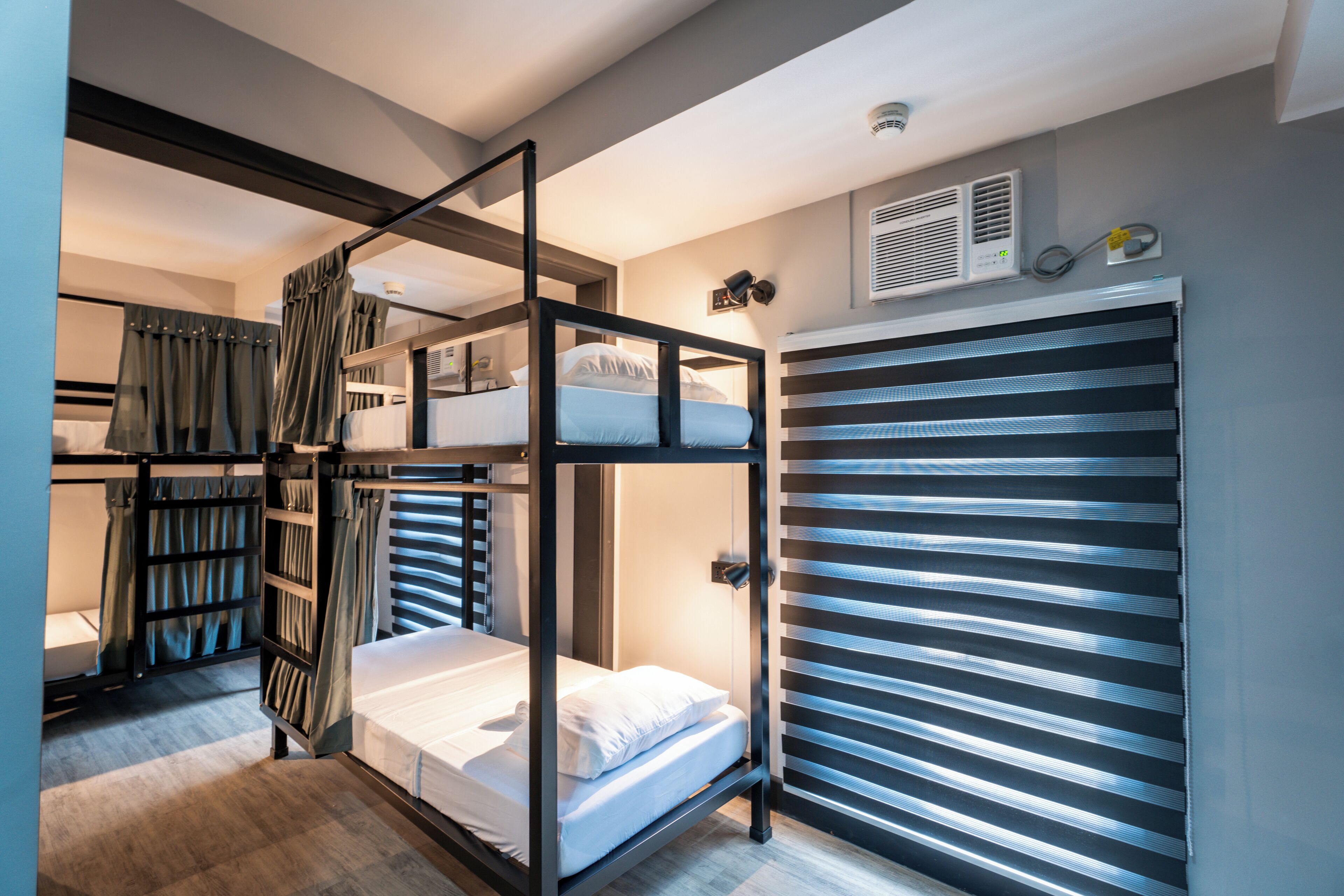 A bunk bed room with a sliding door closet, a built-in heater, and a window with blinds.