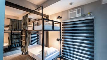 A bunk bed room with a sliding door closet, a built-in heater, and a window with blinds.