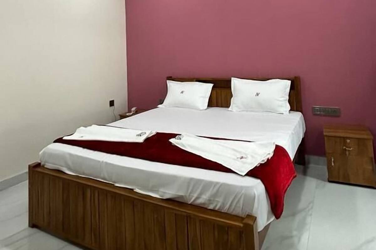 Quarto com cama, ventilador de teto e mesa de cabeceira.