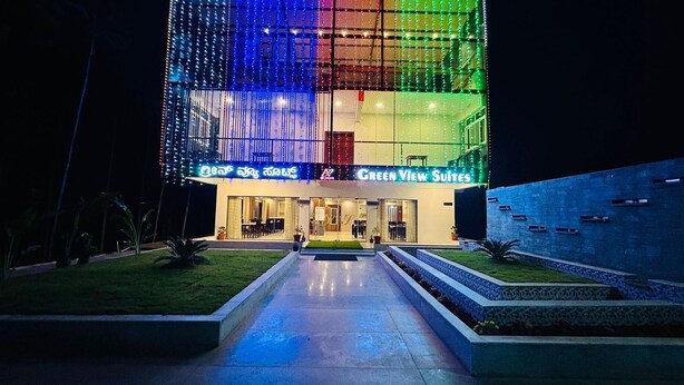 L’entrée d’un hôtel au design moderne, avec une façade en verre et une enseigne lumineuse.