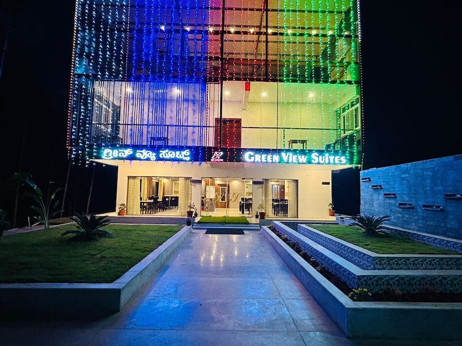 A hotel entrance with a modern design, featuring a glass facade and illuminated signage.