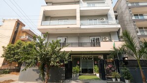 A multi-story residential building with balconies, a gated entrance, and potted plants. - Hotel Royal Galaxy (Gurugram)