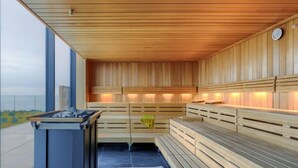 A sauna with wooden benches and a modern design, featuring a large window and a view of the outdoors. - Semi-detached Villa Crveni vrh 1.2.3. by Interhome (Umag/Savudrija)
