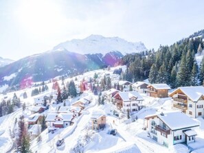 A snow-covered mountain village with wooden houses and a ski slope. - Tga Stgirat Obergeschoss by Interhome (Savognin)