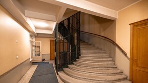 A carpeted staircase with a handrail, leading to a wooden door at the top. - 2ndhomes Bright & Spacious 5BR Apartment (Helsinki)