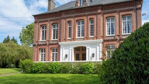 A large brick building with a symmetrical facade, multiple windows, and a central entrance with a white porch. - Le manoir de la belle epoque (Béthencourt-sur-Mer)