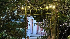 A wooden pathway leading through a garden to a building with a white facade. - Le manoir de la belle epoque (Béthencourt-sur-Mer)