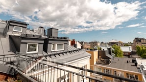 A rooftop terrace with a glass balustrade, a view of the cityscape, and a partly cloudy sky. - 2ndhomes 2BR Penthouse w Terrace&Sauna (Helsinki)