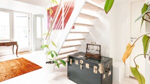 A staircase with white railings and a black trunk with metal latches. - 2ndhomes 2BR Penthouse w Terrace&Sauna (Helsinki)