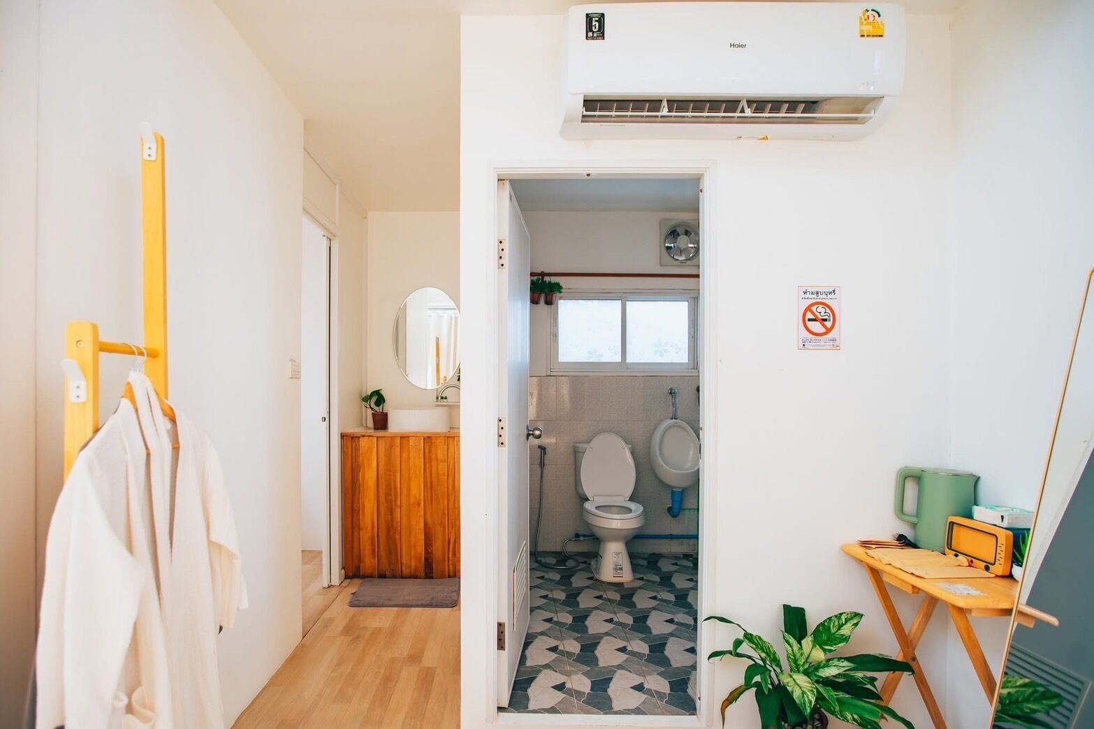 A compact bathroom with a toilet, urinal, and a mirror.