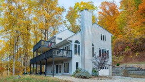 Een modern herenhuis met balkon, omgeven door herfstkleuren.