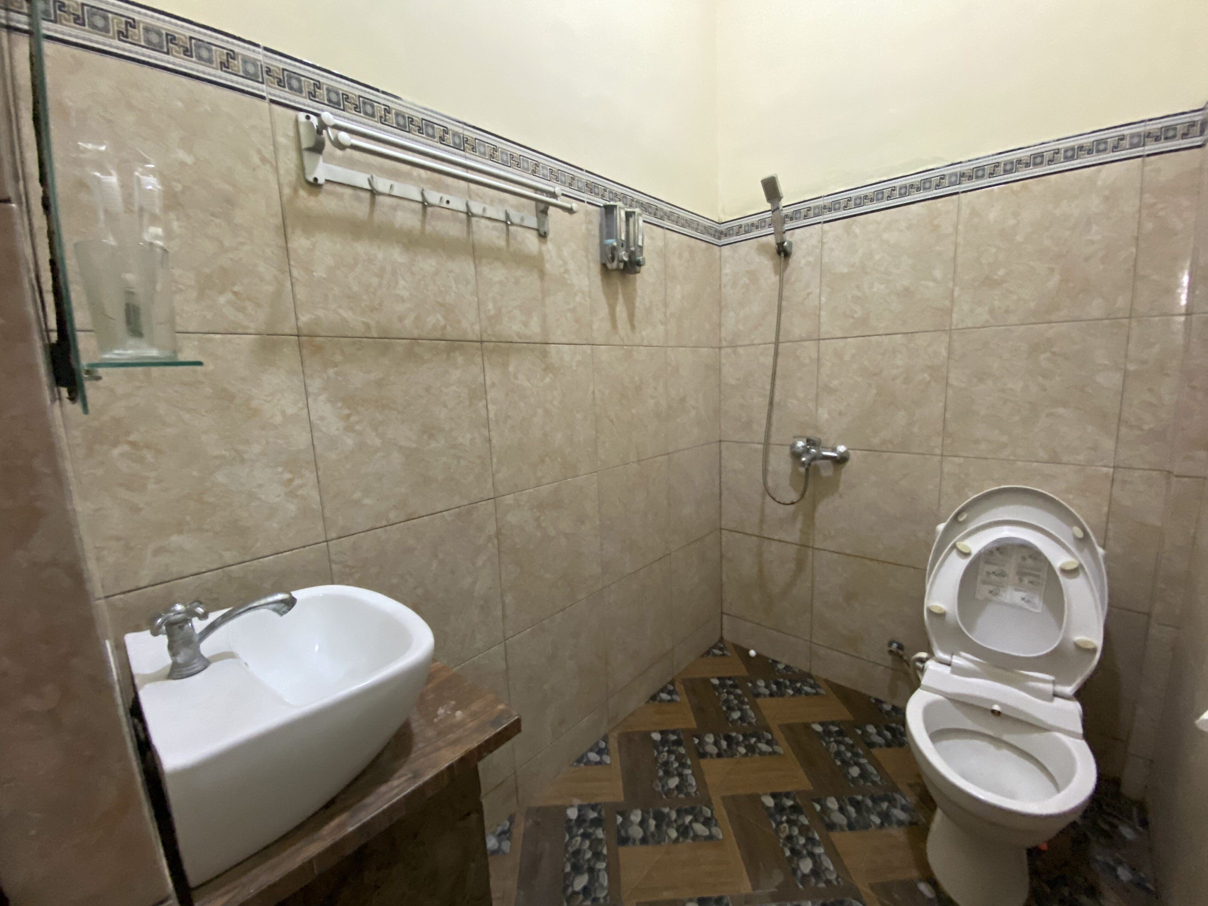 A small bathroom with a sink, toilet, and shower.