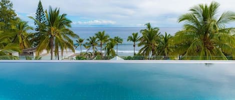 Una piscina al aire libre, sombrillas, tumbonas