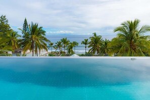 Una piscina al aire libre, sombrillas, sillones reclinables de piscina