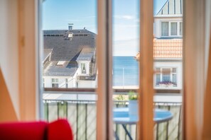 Enjoy the serene view from your room's balcony, featuring a table and chairs, overlooking a body of water and the surrounding landscape.
