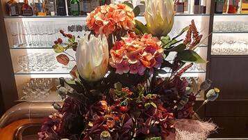 Ein Tisch mit floraler Dekoration und eine Bar im Hintergrund.