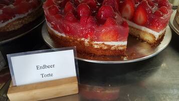 Mansikoilla koristeltu kakku, jonka kyljessä on kyltti, jossa lukee: ”Erdbeer Torte”.