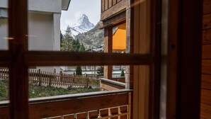 A wooden balcony with a view of a mountain and a wooden fence. - Baccara Studio  (Zermatt)