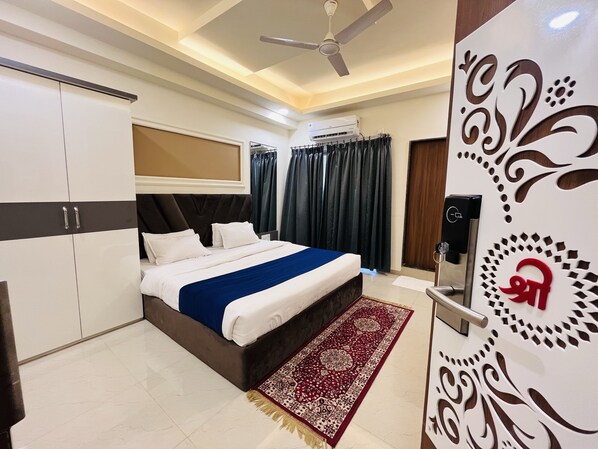 A bedroom with a bed, wardrobe, ceiling fan, air conditioning unit, and decorative wall panel. - Hotel Shree Palace (Ujjain)