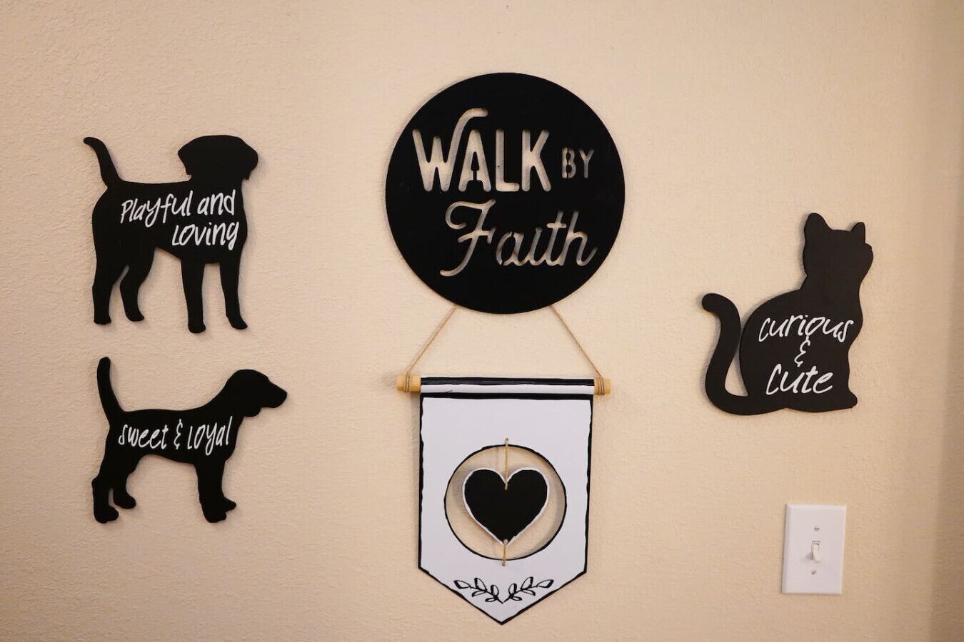 Un mur orné de silhouettes de chiens décoratives et une pancarte sur laquelle on peut lire : « AVANCEZ PAR LA FOI ».