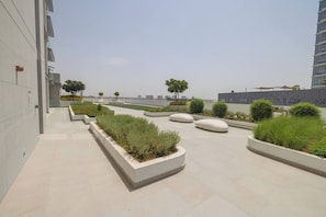 A modern outdoor area with planters, seating, and a clear sky.