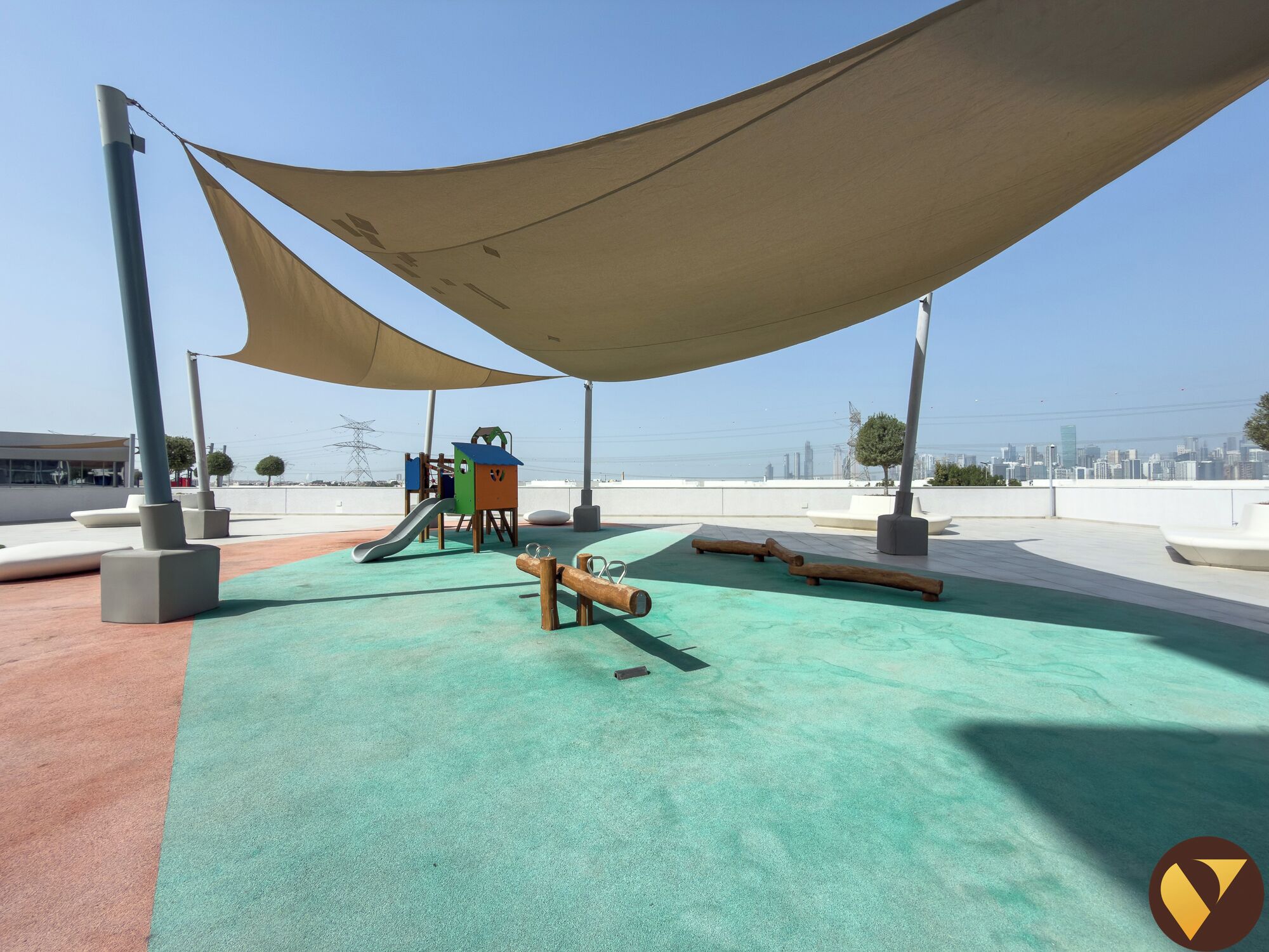 A playground with a slide, climbing structures, and shaded areas.