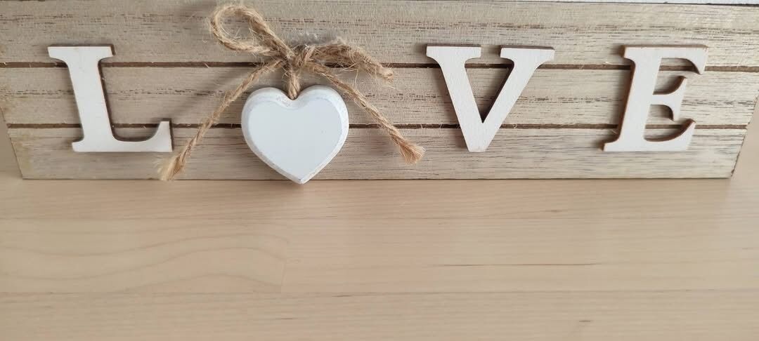Un letrero de madera con la palabra 'LOVE' y un adorno con forma de corazón.