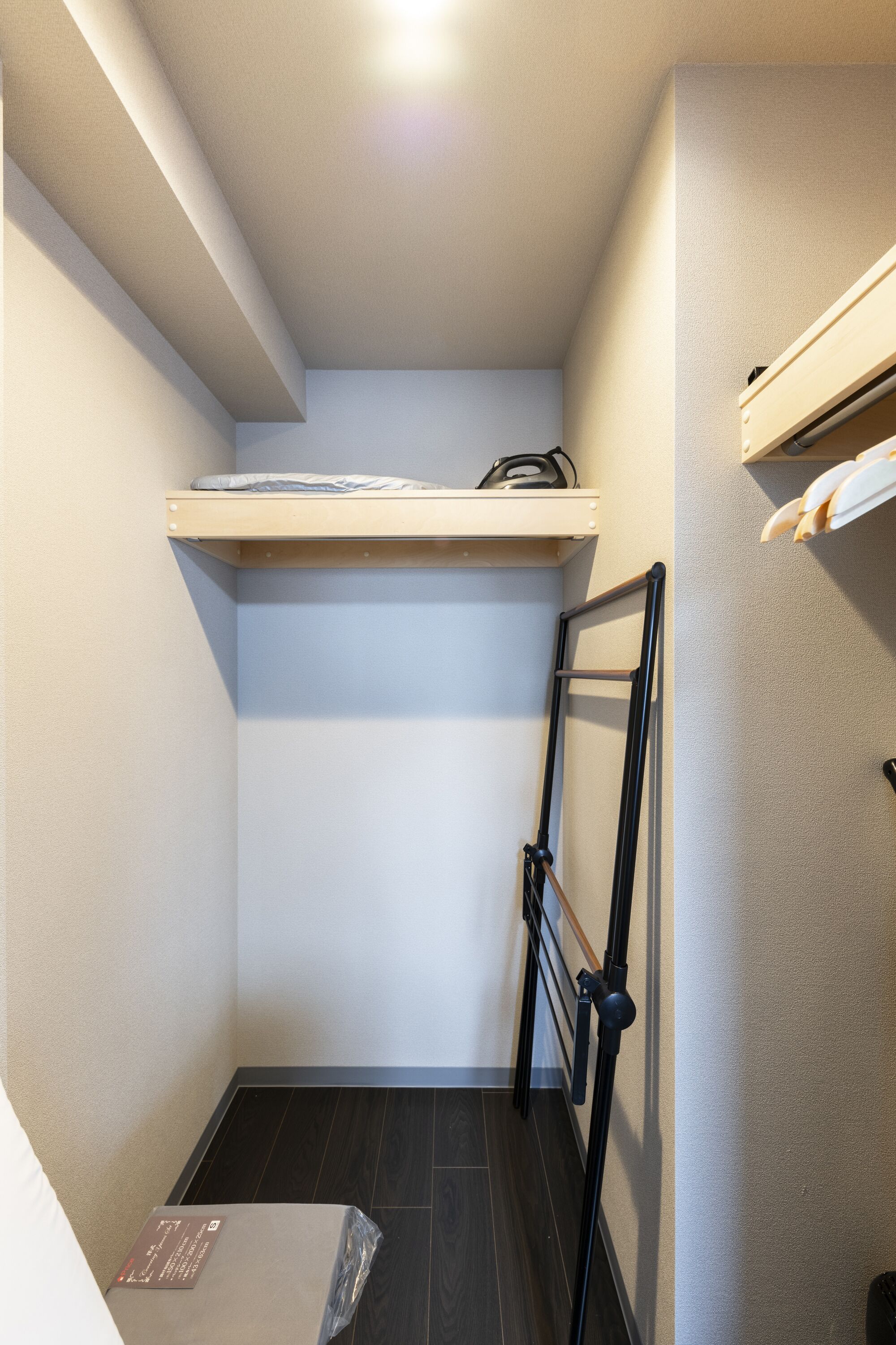 A small, narrow room with a bunk bed, a shelf with a mattress, and a ladder.