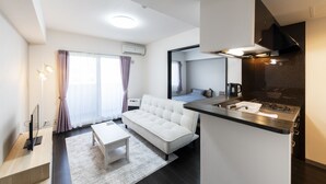 A modern apartment with a living area, kitchenette, and a bedroom. - STARGAZE 602 (Sapporo)