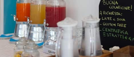 Un sector de bebidas con botellas etiquetadas y un menú en una pizarra que ofrece opciones como latte, sin gluten y espresso.