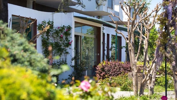 A modern building with a white facade, large windows, and a green roof. - Hotel Sporting (Vasto)