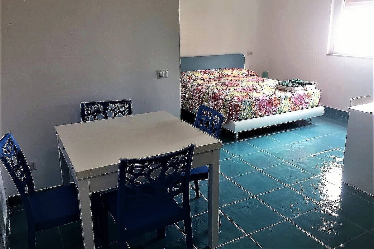 A small room with a bed, a table, and two chairs.