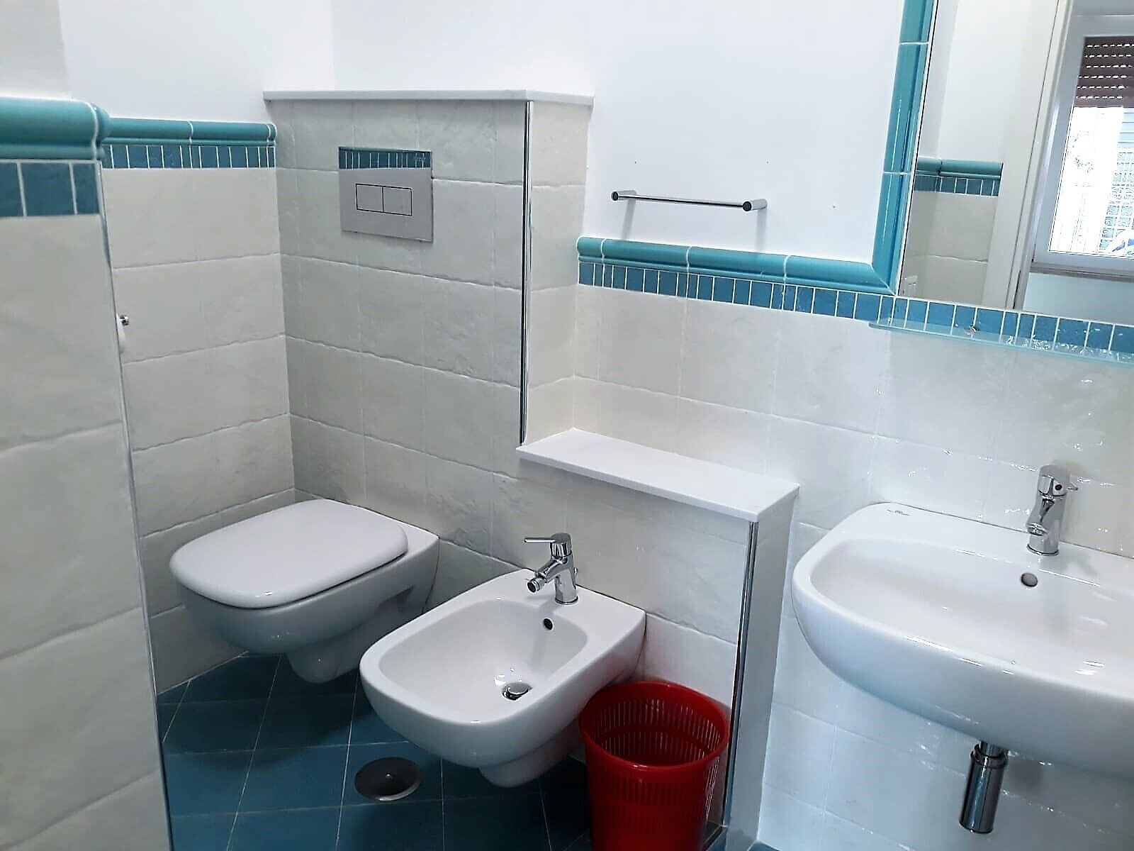 Ein kleines Badezimmer mit Toilette, Bidet und Waschbecken.