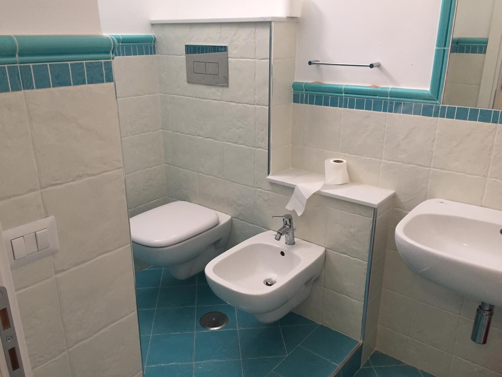 A small bathroom with a toilet, bidet, and sink.