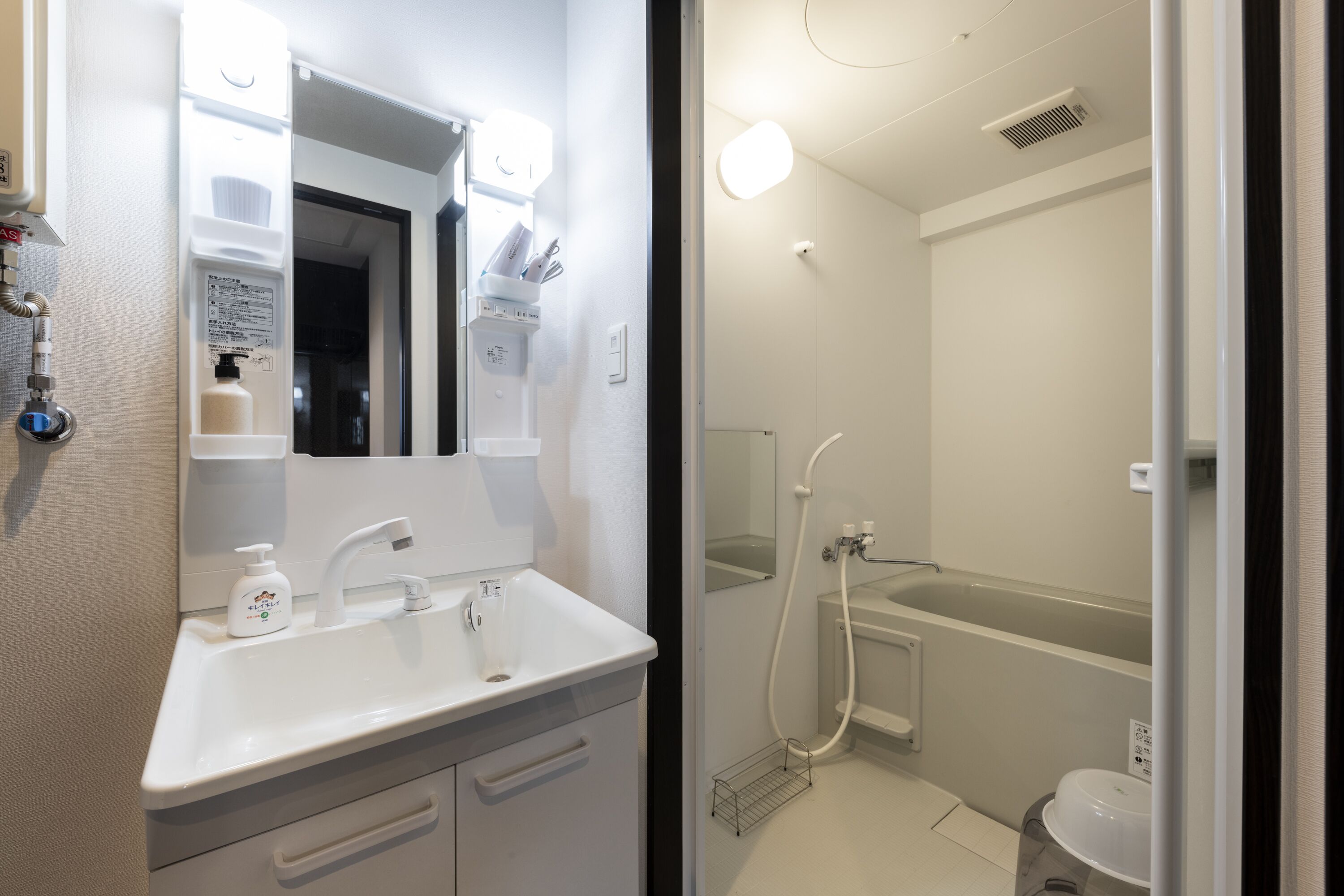 A modern bathroom with a white sink, mirror, and shower.