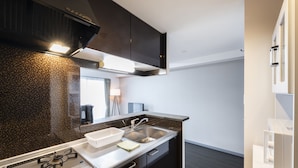 Una cocina moderna con gabinetes oscuros, un lavamanos de acero inoxidable y una estufa a gas.
