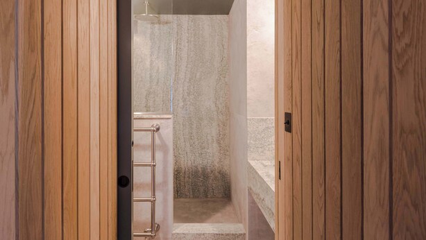 A wooden door leading to a bathroom with a marble shower and a towel rack. - Top-Floor Soho Flat | AC | Sleeps 4 | Central Ldn (Greater London)