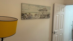 Eine Wand mit einem Gemälde eines Strandhauses und einer geschlossenen Tür.