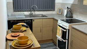 Eine kleine Küche mit Geschirrspüler, Herd und Backofen.
