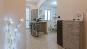 A modern kitchen with a central island, bar stools, and a wooden cabinet. - Modern House Santa Rita by Wonderful Italy (Turin)