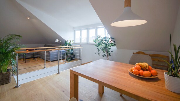 A modern dining area with a wooden table, a fruit bowl, and potted plants. - Moderne, Helle Wohnung (Heidelberg)